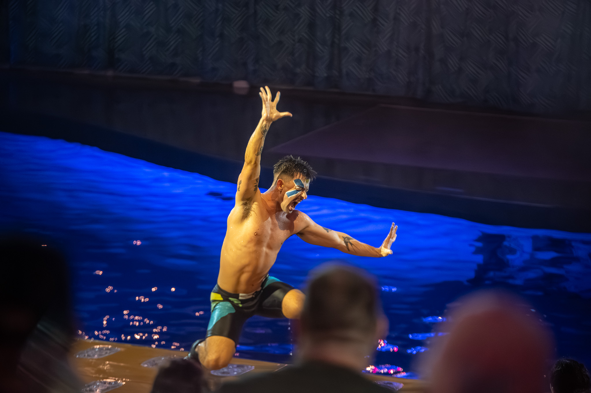 Performer with bold makeup and motion in a live water show