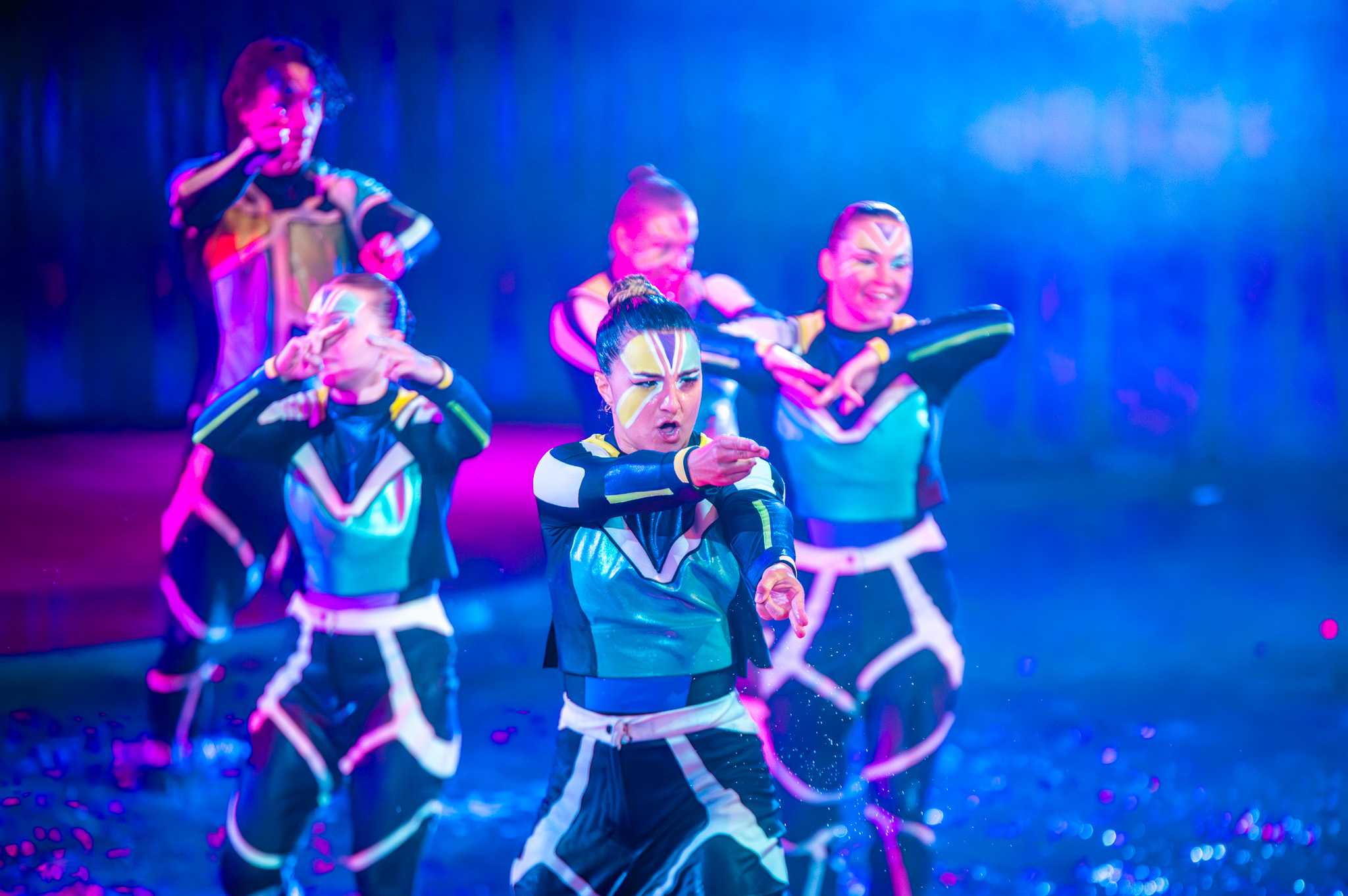 Performer dancing across the water with colorful lighting