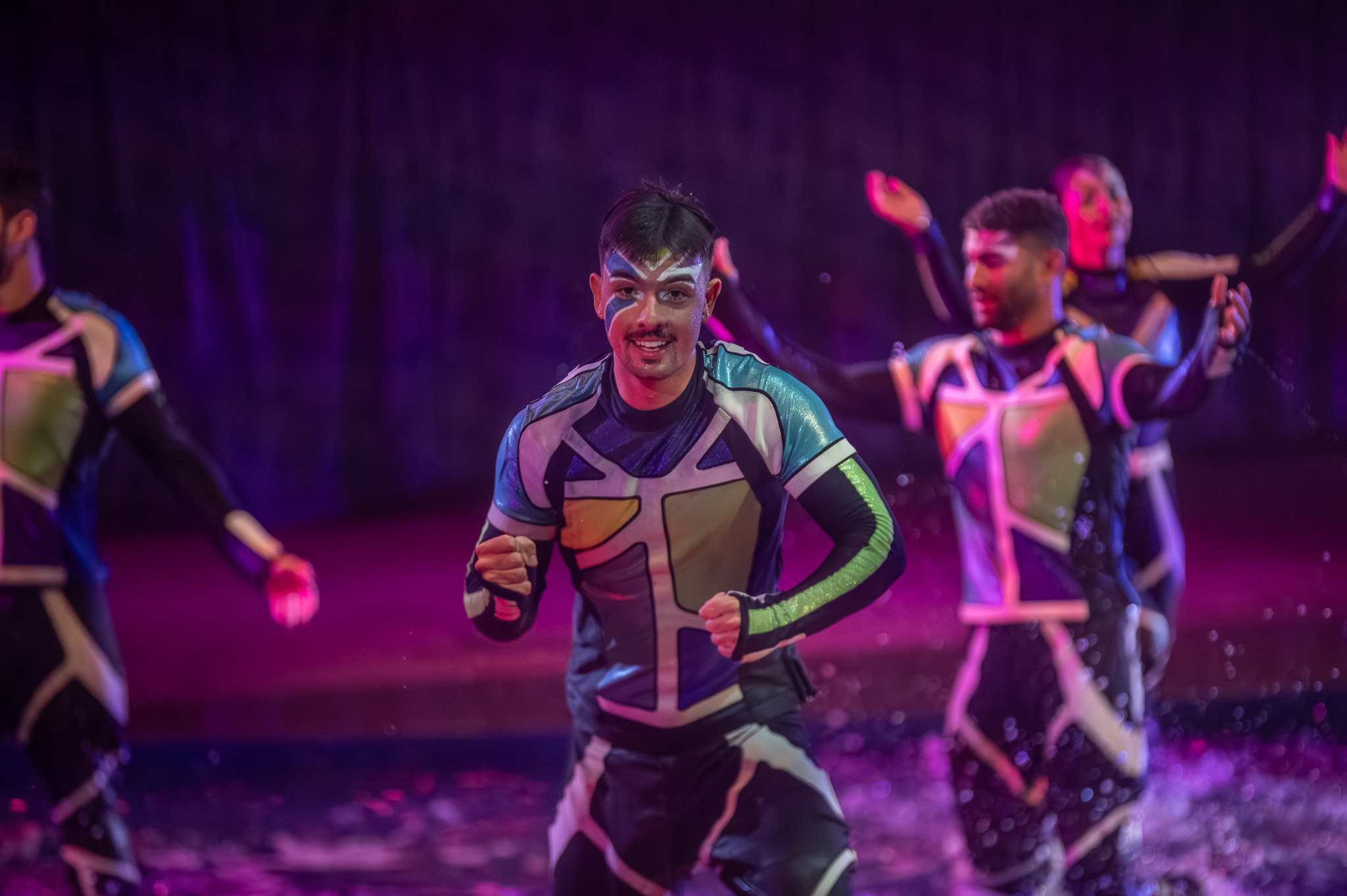 Performer celebrating in the water during a stage production