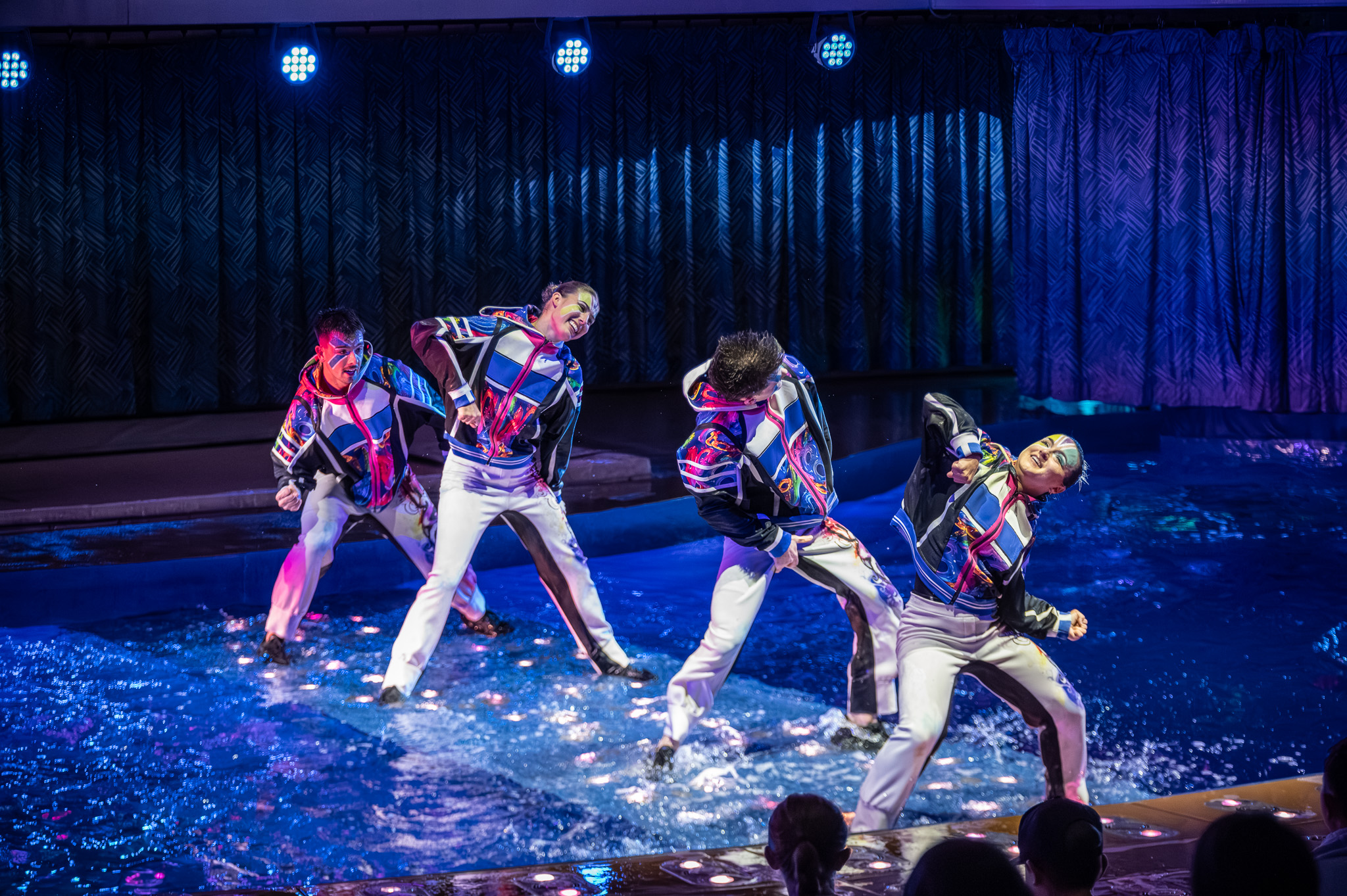 Performer throwing water upward during a live sequence