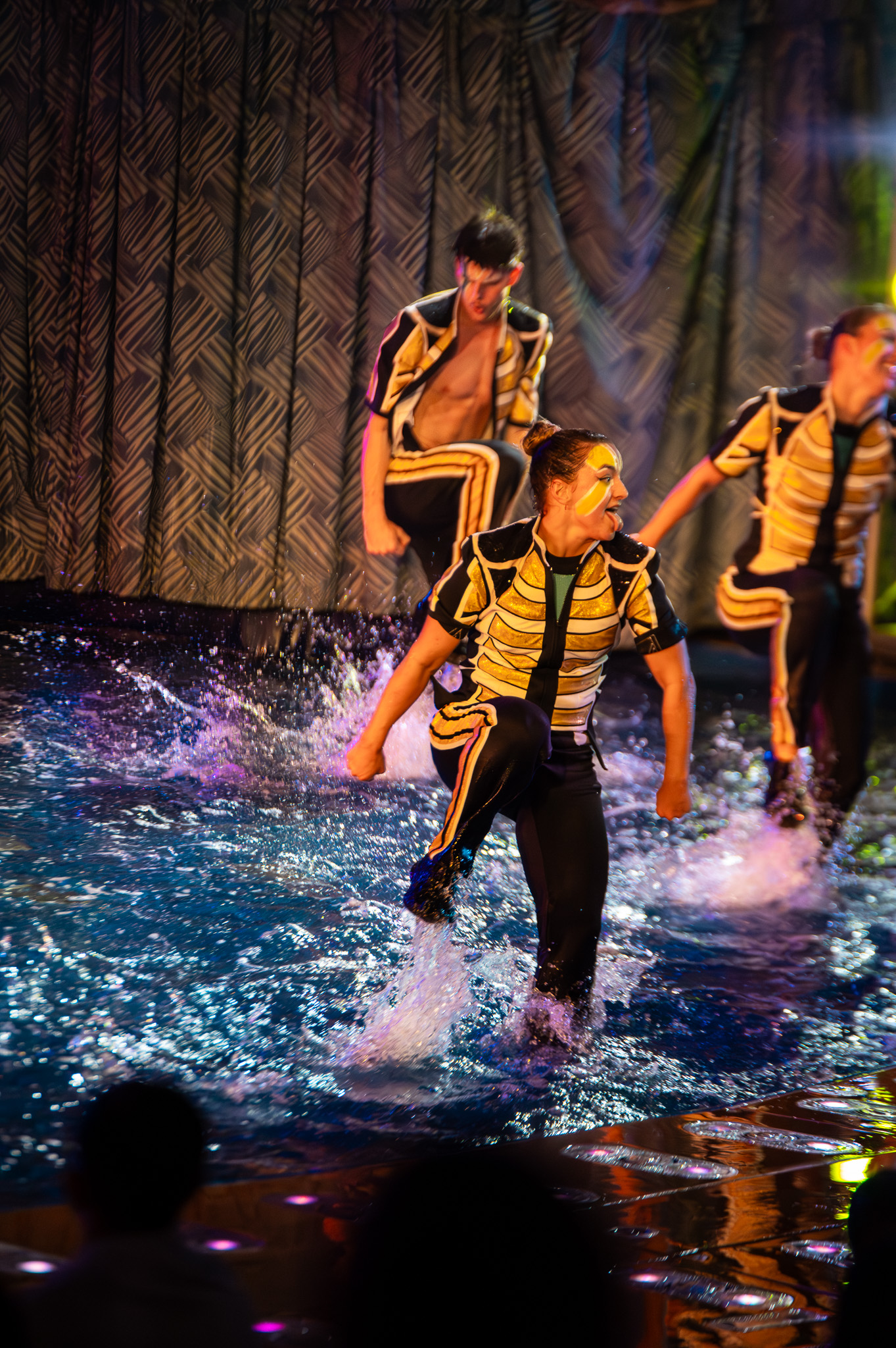 Group choreography in the water under strong stage lighting